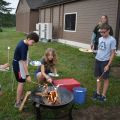Teens roasting marshmallows around a campfire