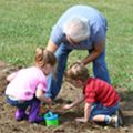 three people planting a garden