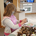 girl painting pine cones