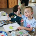 boy holding up art project