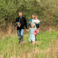 family walking in meadow in spring
