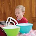 child with mixing bowls and science experiment