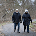 man and woman taking a winter walk on a park trail