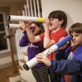 three children looking through homemade telescopes