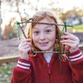 young girl looking through frame of sticks