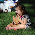 little girl sitting with stuffed teddy bear