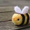 needle felted bee on a picnic table