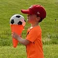 child holding a soccer ball in an upside down cone