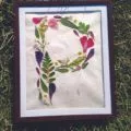 framed pressed flowers in the shape of the letter P