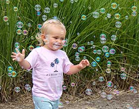 Smiling toddler surrounded by bubbles