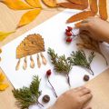 close up of a child's hands creating artwork with items from nature