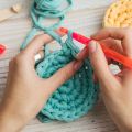 hands crocheting a blue circle