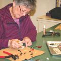 a woman working on glass fusing art