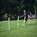 child running through pool noodle maze