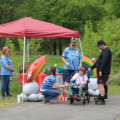 five people enjoying an accessible walk on a paved path with a tent set up and activities to experience