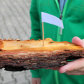 a child's hand holding a boat made out of natural materials