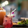 two fancy mocktail drinks on a table with a salad