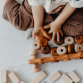 a child playing with miscellaneous loose wooden toys and items