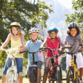 four children on bikes wearing helmets