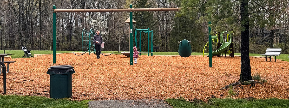An adult and a toddler at a park playground
