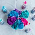 tshirt on a table in the process of getting tie dyed with multiple colors