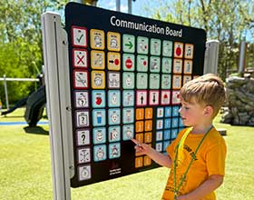 child using a communication board at a park