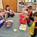 four children stirring batter