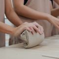 hands folding and shaping clay