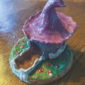 fairy house made out of clay and hand painted with a purple roof