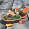 small wooden bowl filled with fall themed decor to create a thanksgiving table centerpiece