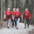 four people walking on a path wearing matching red turkey trek shirts