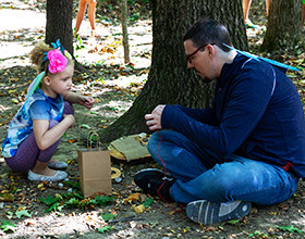 Father and daughter building fairy home in the forest