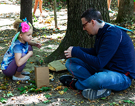 Father and daughter building fairy home in the forest