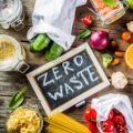 a flat lay photo of a sign that says zero waste with food surrounding it