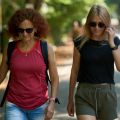 two women walking together on a paved path