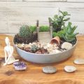 a tabletop peaceful potted garden with succulents, stones, and bridges