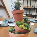 a tower of 3 terracotta pots with succulents planted inside