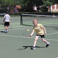 two children with tennis racquets and tennis balls on a tennis court