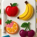 hand stitched felt magnets representing an apple, banana, orange, and cherries