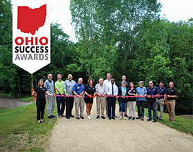 Ohio Success Award banner over an image of people standing across a limestone path cutting a red ribbon