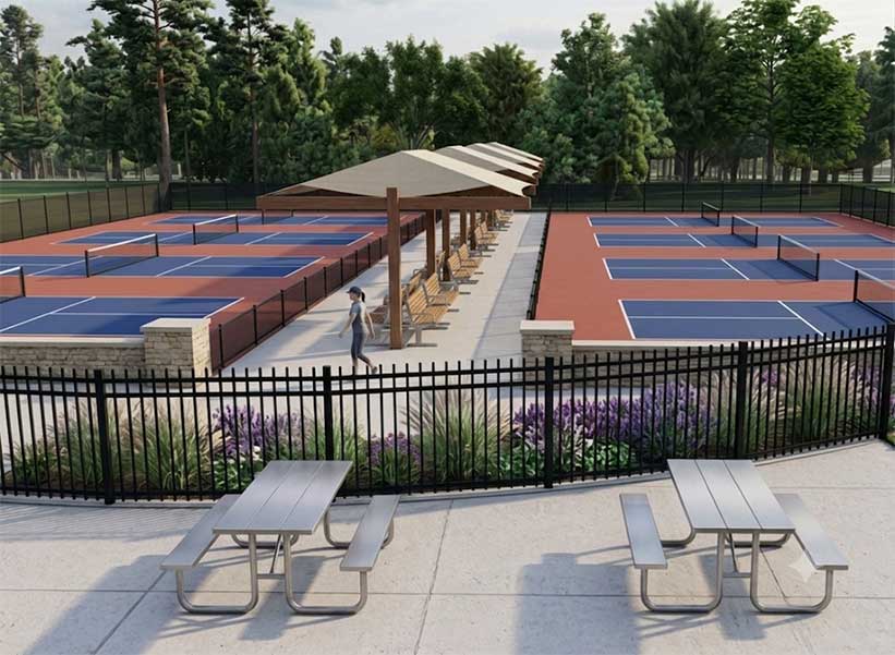 Rendering of a person standing on pickleball courts with benches underneath shade structures. Two picnic tables are in the foreground.