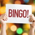 two hands holding up a sign that says bingo written in red