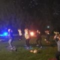 a group of people practicing yoga next to a campfire