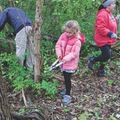 a young girl pruning a honeysuckle bush in the woods