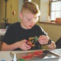 a boy wearing safety glasses and working on a glass fusing project