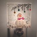 glass fused night light with a snowman image on it