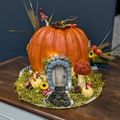 a pumpkin decorated with various whimsical trinkets to make it look like a fairy house