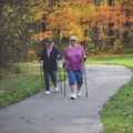 two women on a trail walking with nordic poles in the fall