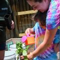 a mother and daughter watering a plant together