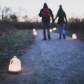 people walking a candlelit snowy path at Forest Field Park